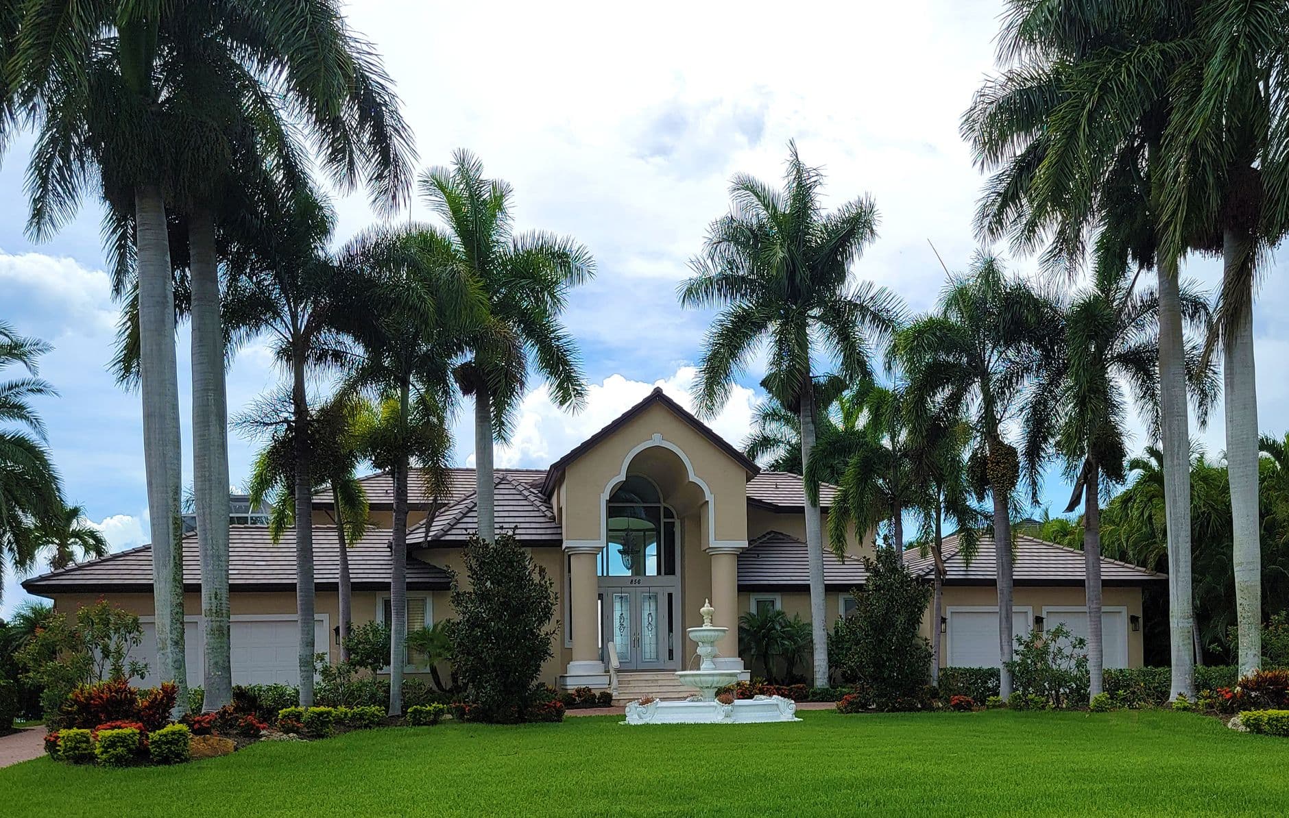 Florida luxury home exterior framed by mature palm trees